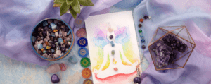 A painting of a person meditating with chakra stones laid around it